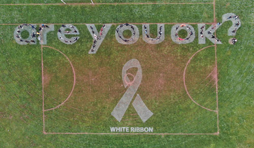 Students spell out Are You OK on the sports field
